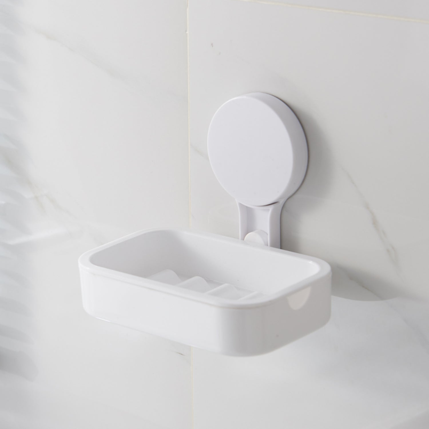 jabónera blanca montada en pared, baño con azulejos claros