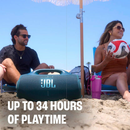 Grupo de amigos disfrutando en la playa con el parlante portátil JBL Boombox 4 que ofrece hasta 34 horas de reproducción