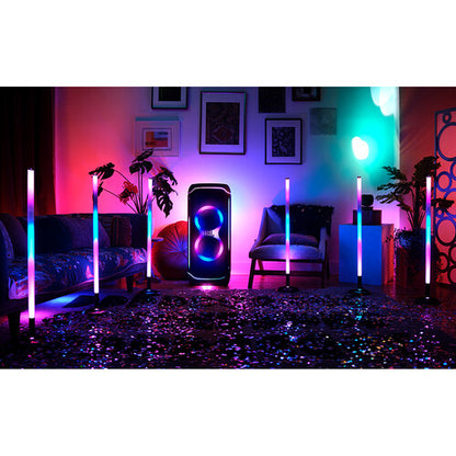 Ambiente festivo con la barra de luz JBL PartyStick RGB y luces multicolores en una sala de estar moderna