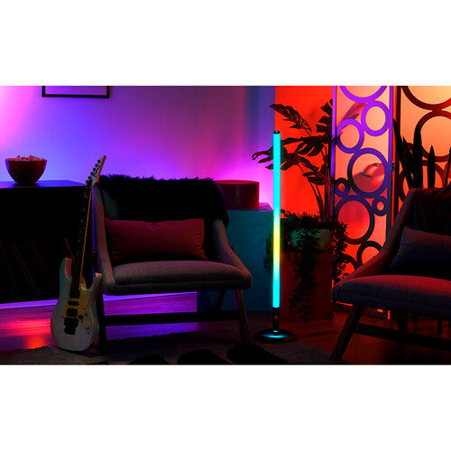 Barra de luz JBL PartyStick RGB iluminando una sala de estar moderna con colores vibrantes