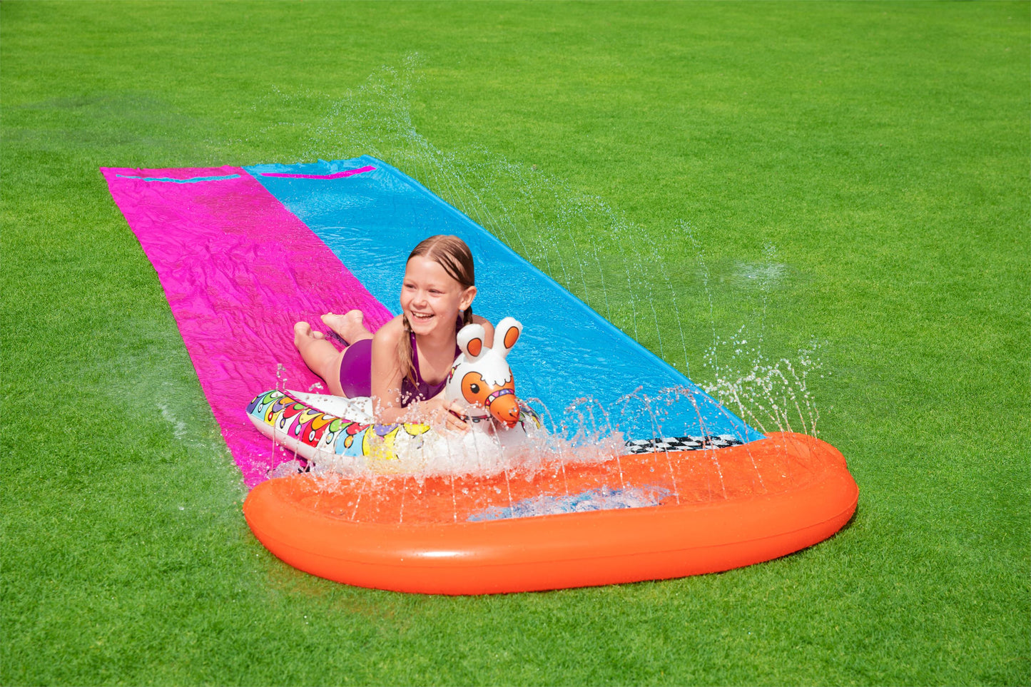 juego de verano para niños Honduras, alfombra inflable, niña jugando en el césped