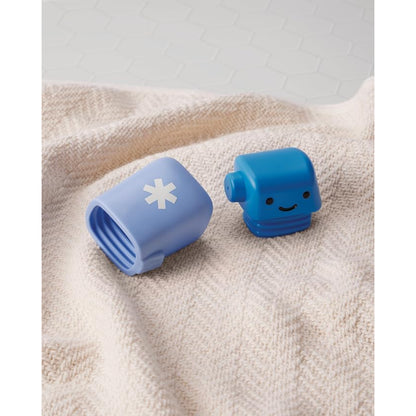 Juego de juguetes de baño en colores azul y blanco sobre una toalla
