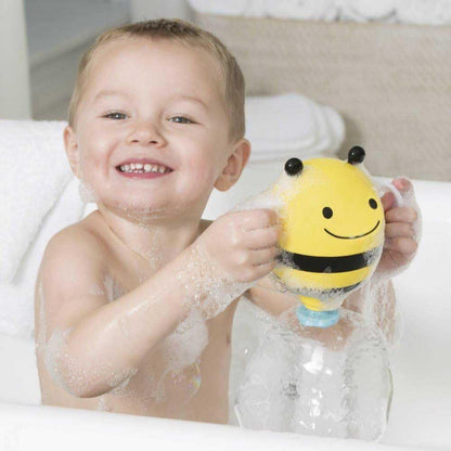 Niño feliz con juguete de baño en forma de abeja, jugando en la bañera con burbujas
