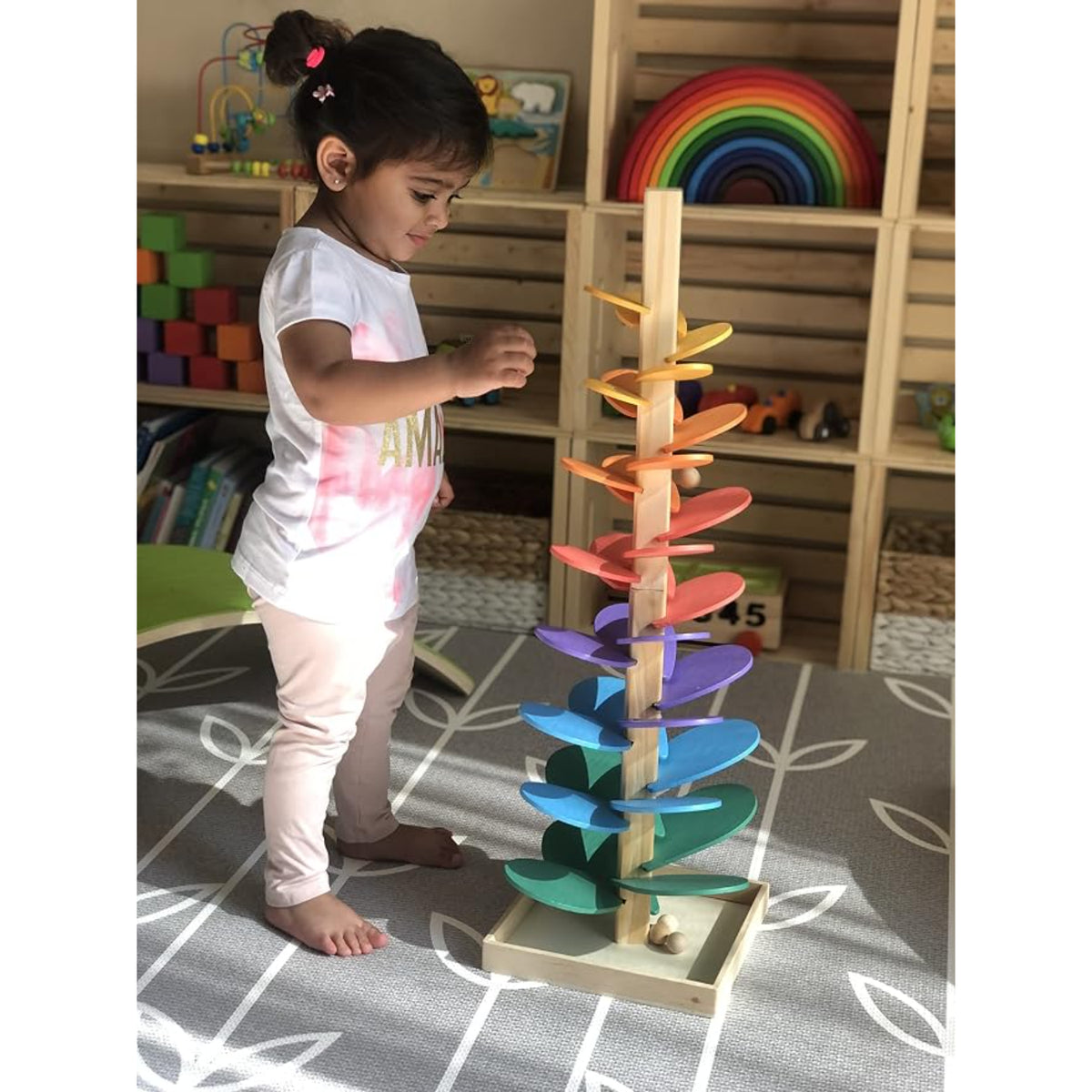 Juego de habilidades motoras, torre de colores, niña jugando en sala de juego