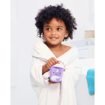 Niña con bata sosteniendo cubo morado SKIP*HOP, baño divertido y acogedor