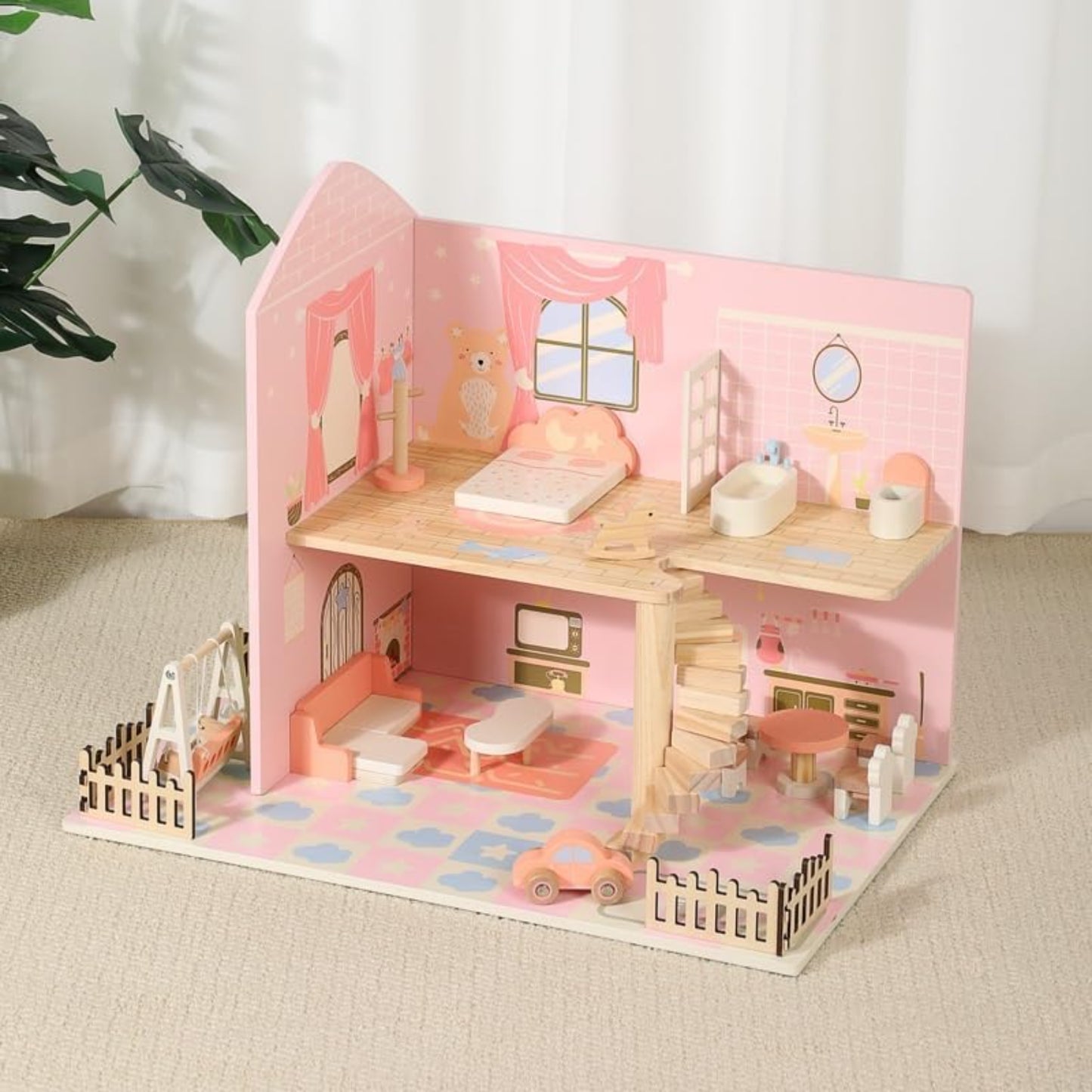 Casa de muñecas rosa con muebles de madera, vista interior en sala de estar