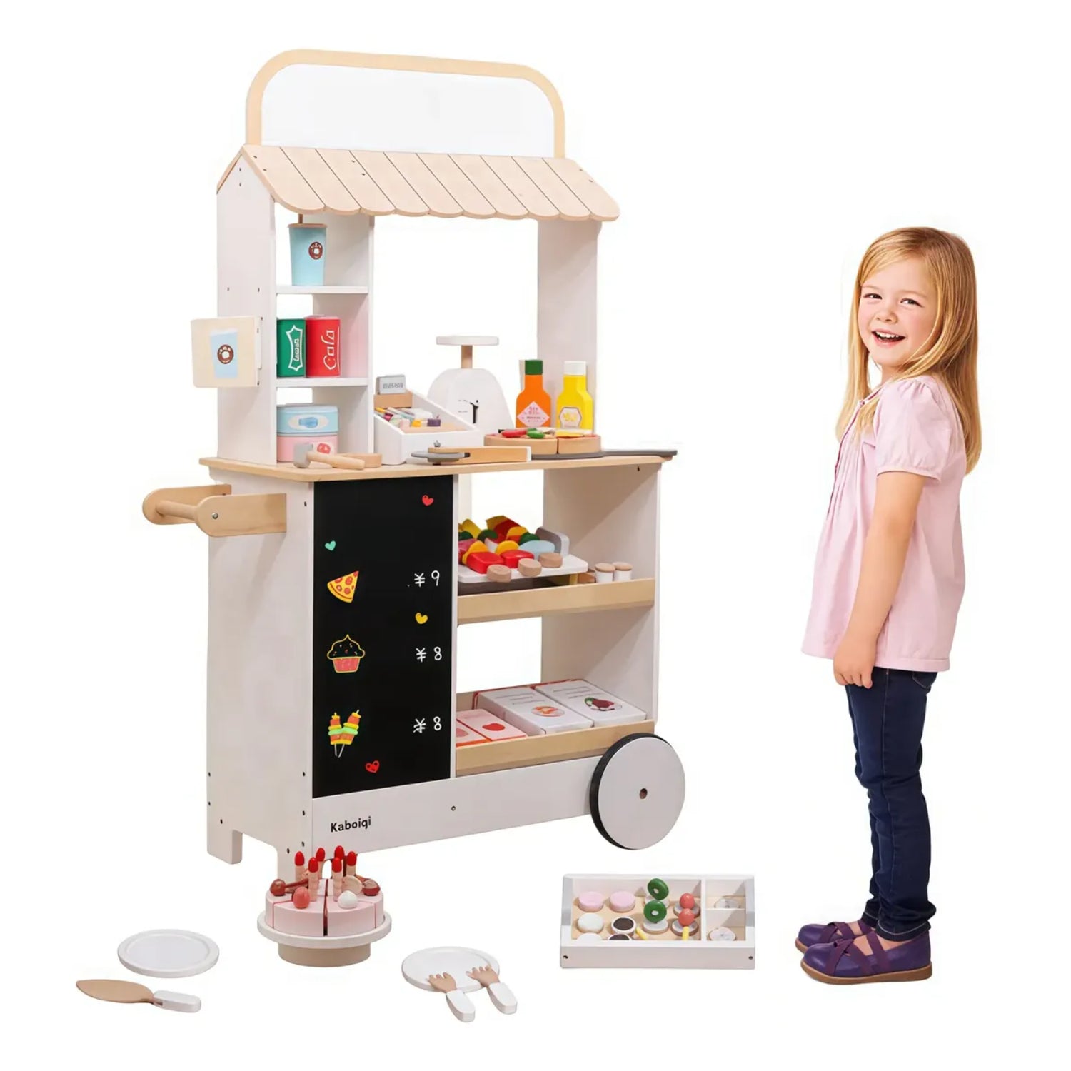 Carrito de madera con comida de juguete, niña sonriendo junto a él