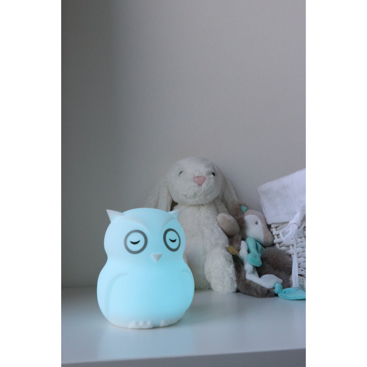Lampara búho azul suave, iluminación infantil junto a juguetes en habitación