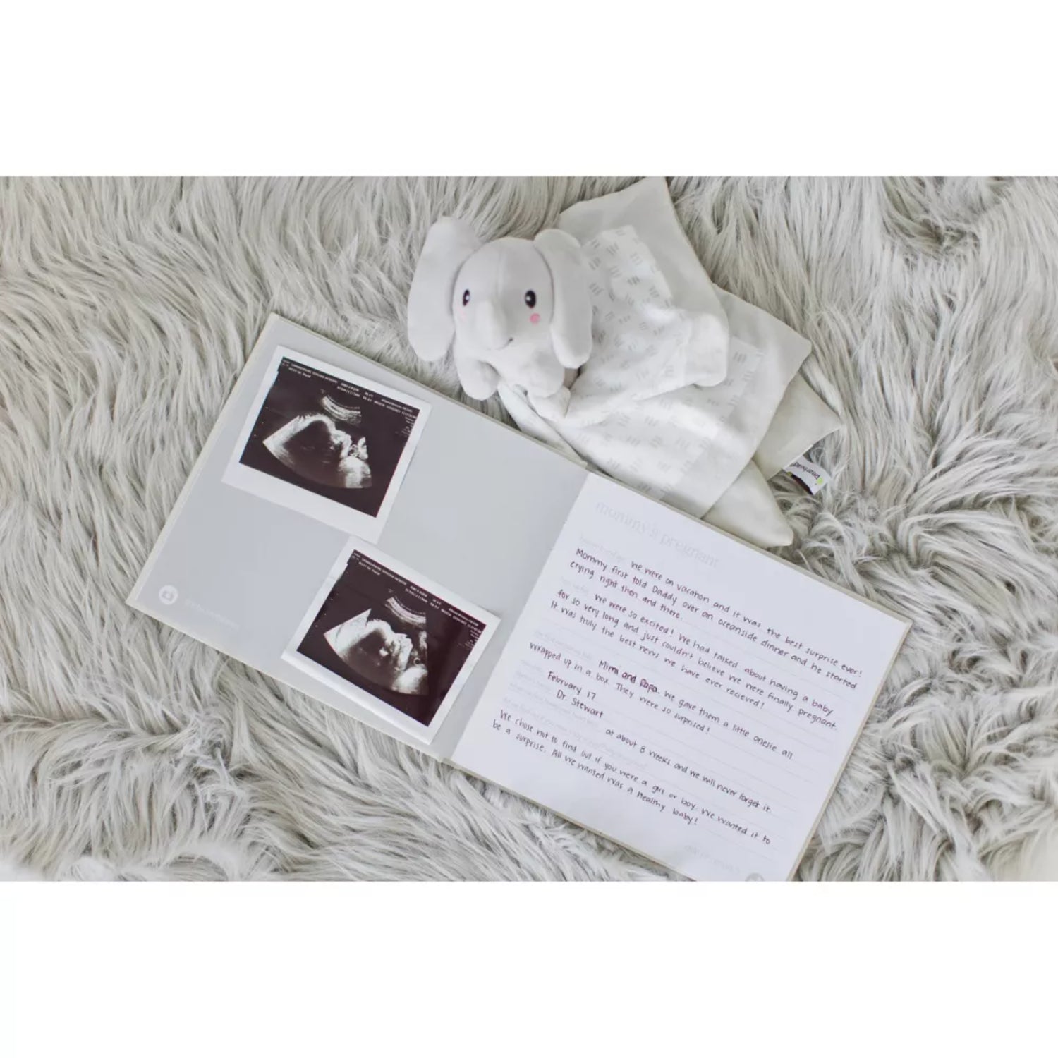libro de recuerdos blanco abierto con fotos de ultrasonido y un peluche de elefante