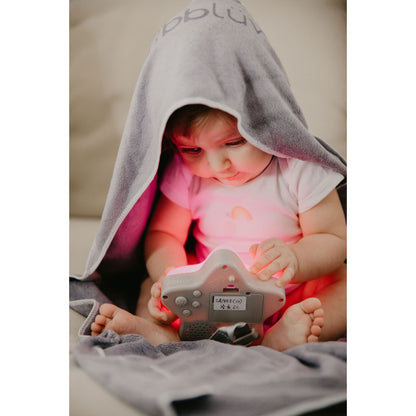 Luz noctur de BBLUV en gris, bebé jugando en casa, envuelto en toalla