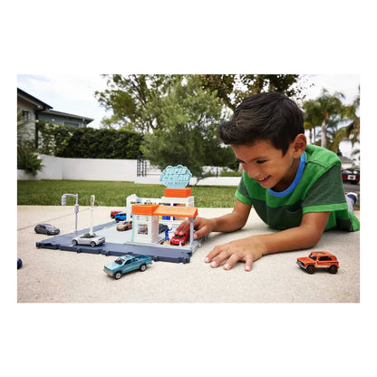Niño jugando con juego de coches LL0308 de Mattel, vista frontal en el patio