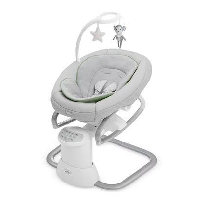 mecedora Graco gris con vibración y móvil, vista frontal en habitación infantil