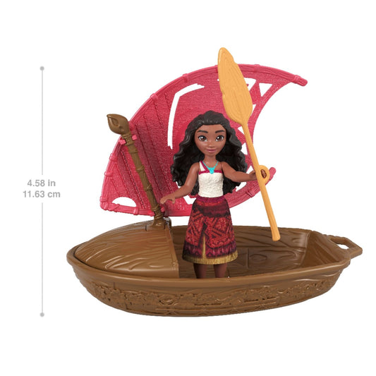 Muñeca Moana con bote marrón y vela roja, jugando al aire libre