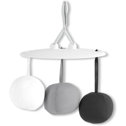 Móvil para bebés blanco y gris con bolas colgantes en habitación infantil