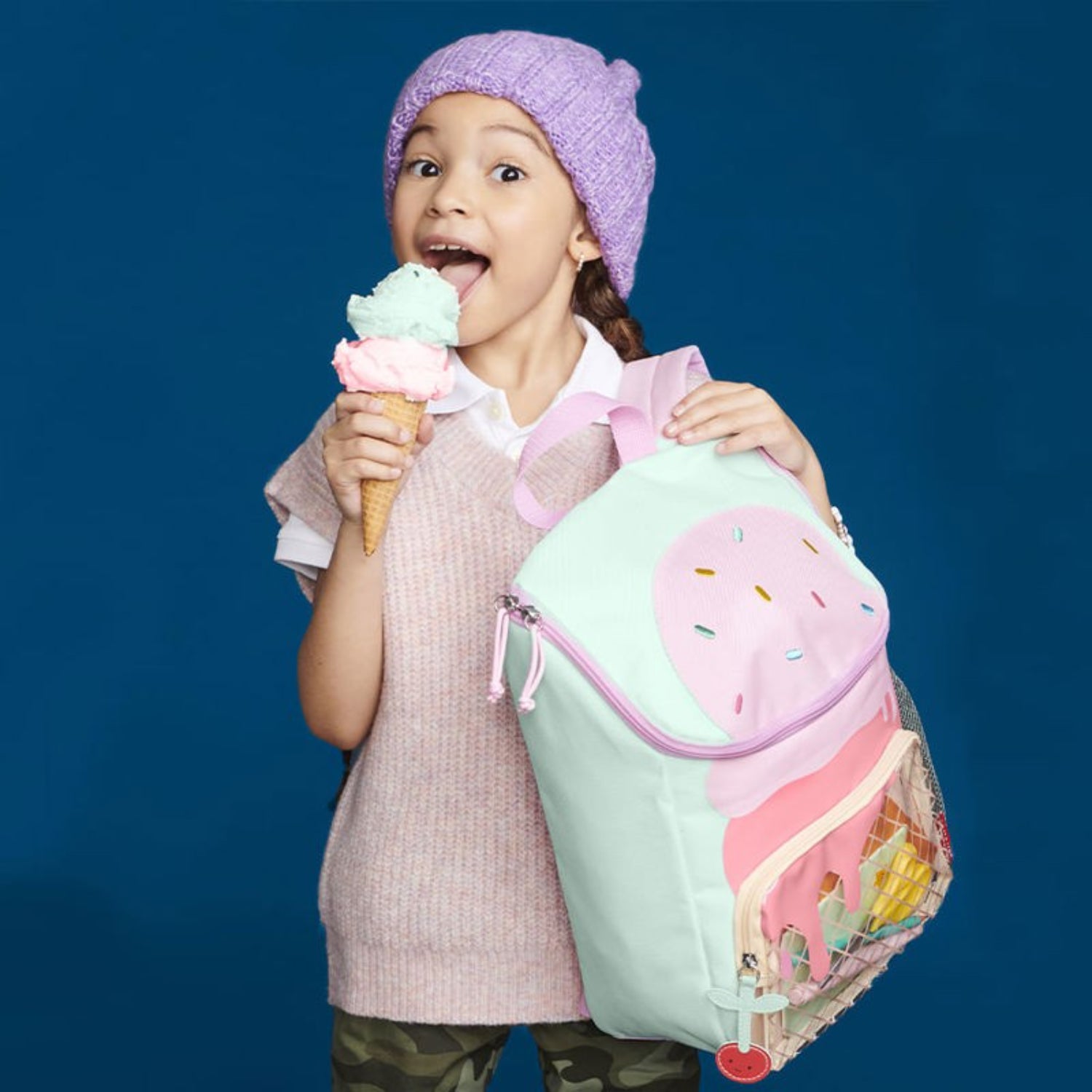 mochila escolar rosa y verde, niña feliz sosteniendo helado
