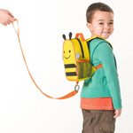 mochila infantil amarilla con diseño de abeja, vista lateral, niño usando en parque
