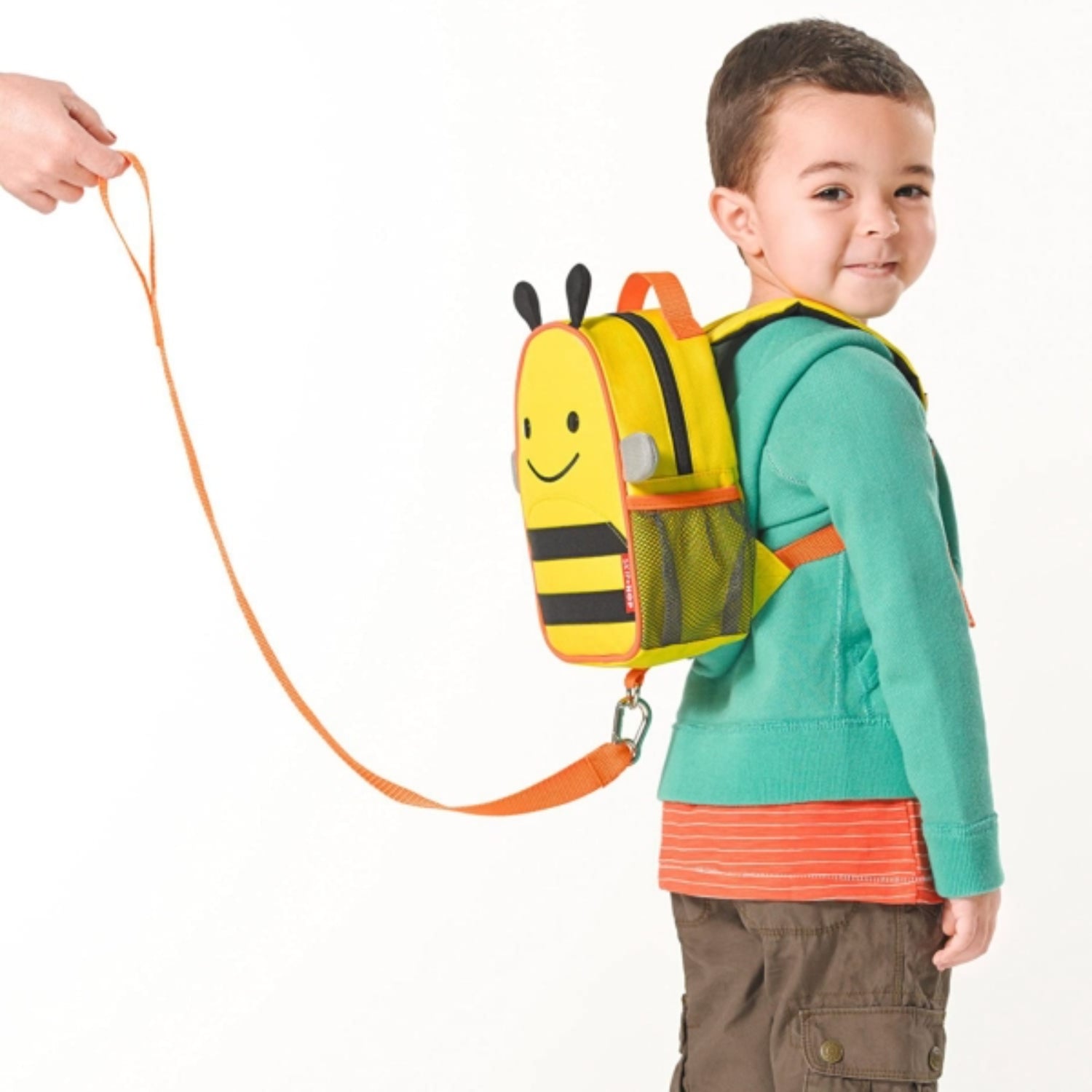 mochila infantil amarilla con diseño de abeja, vista lateral, niño usando en parque
