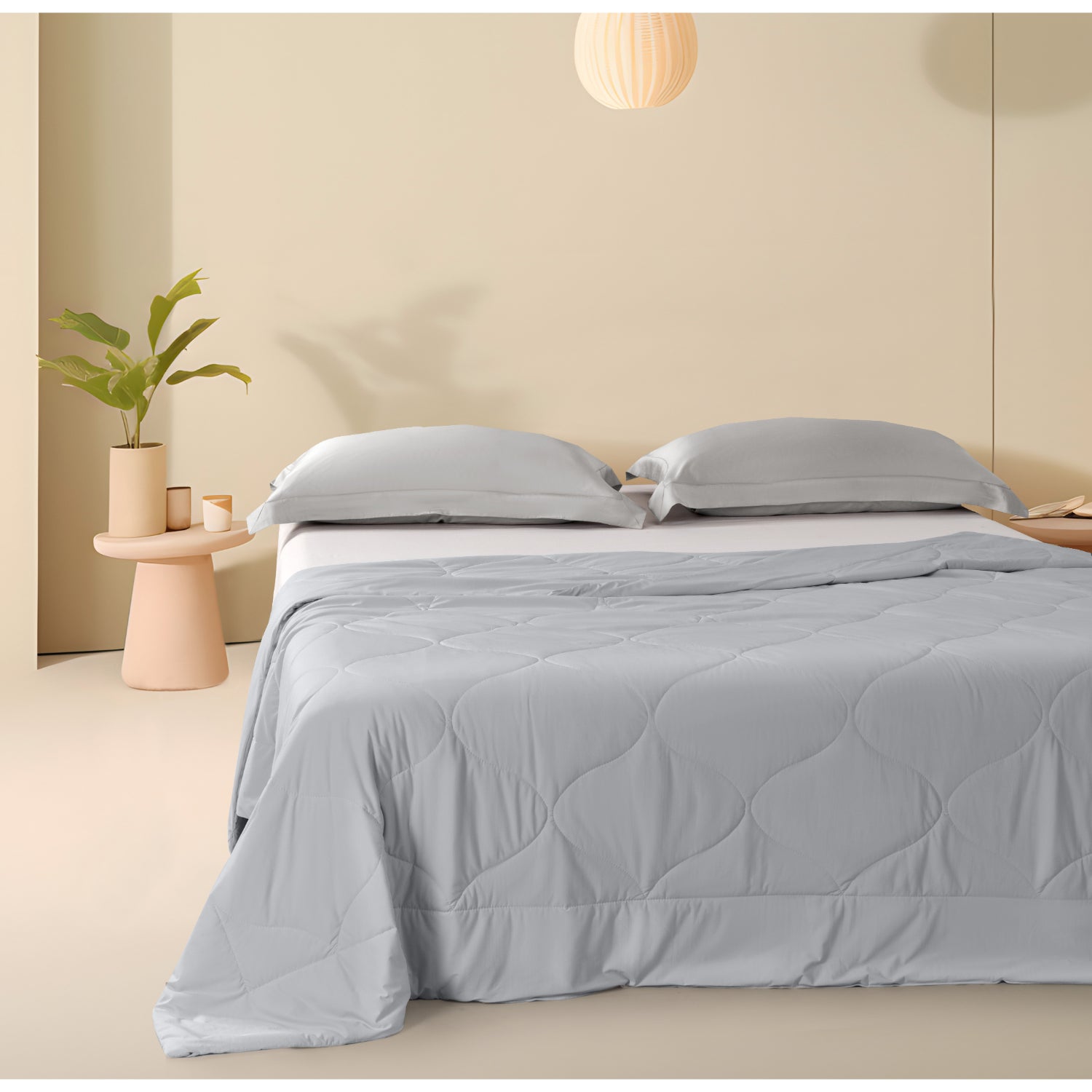 Colcha refrescante queen gris sobre cama moderna en dormitorio minimalista con almohadas a juego