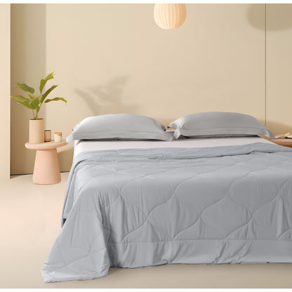 Colcha refrescante queen gris sobre cama moderna en dormitorio minimalista con almohadas a juego