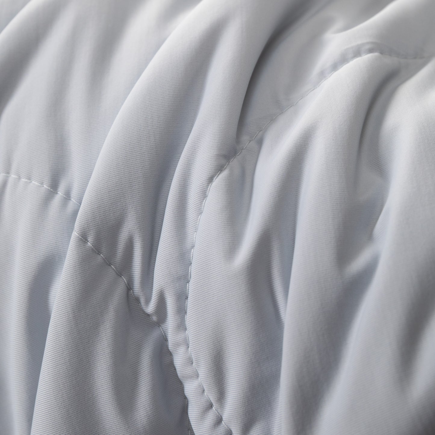 Detalle de la textura suave y costuras de la colcha refrescante queen en color blanco