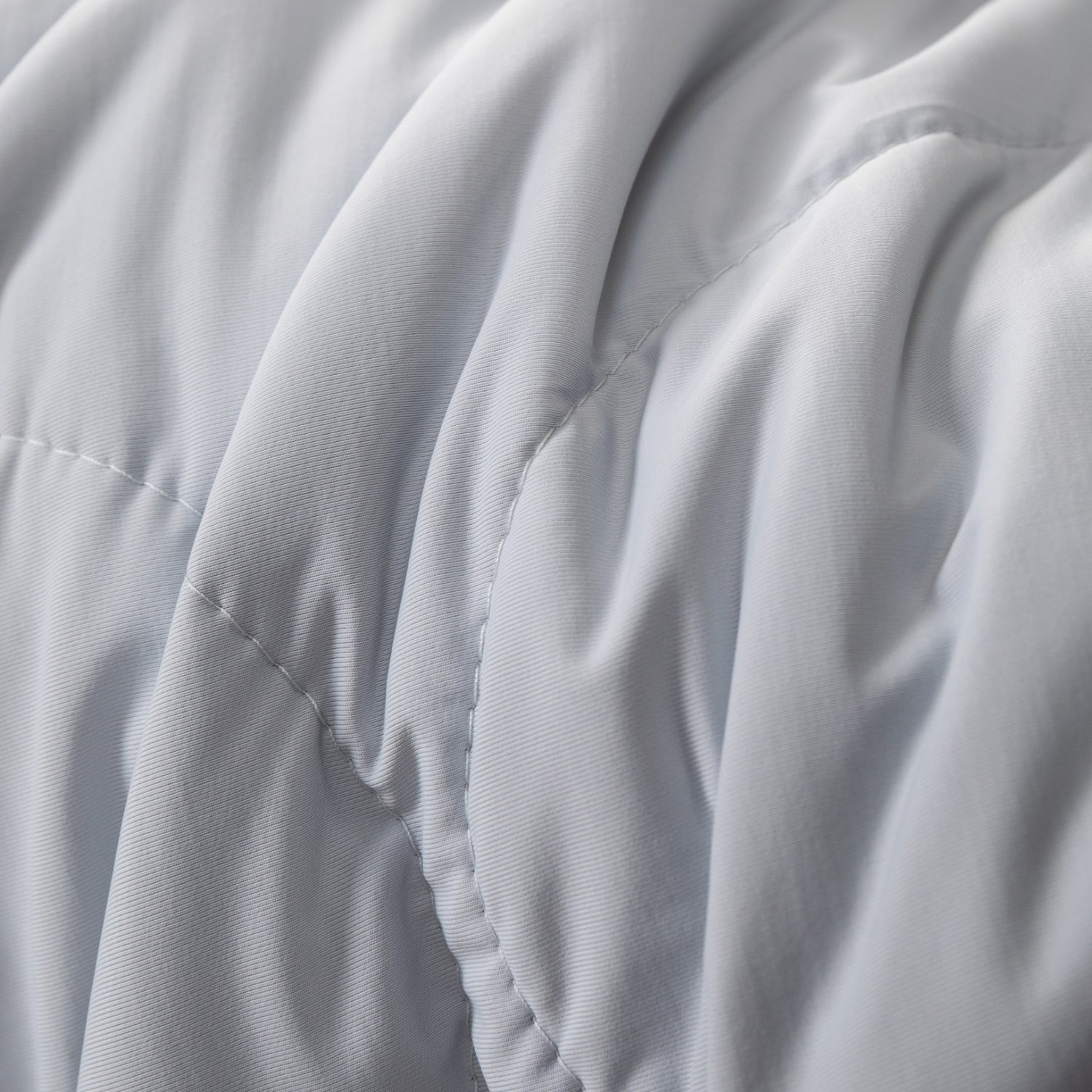 Detalle de la textura suave y costuras de la colcha refrescante queen en color blanco