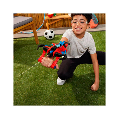 Pistola de agua roja y negra, niño jugando en el jardín con balón