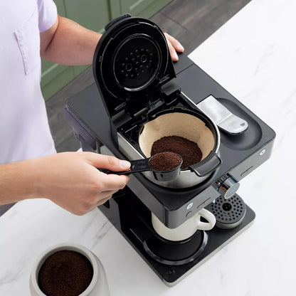 Cafetera negra con filtro y café molido, vista superior en cocina