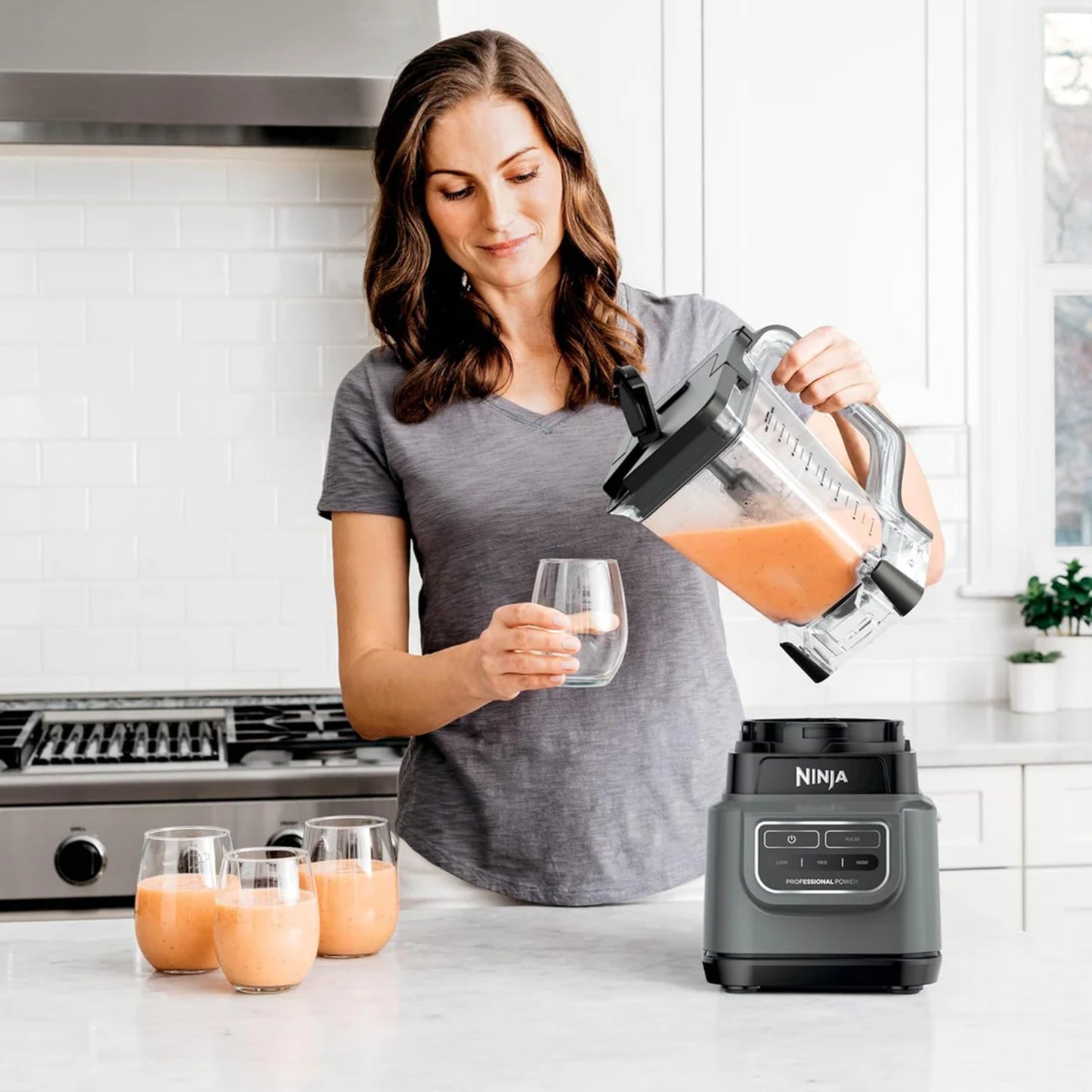 Mujer usando licuadora Ninja para preparar jugo saludable en cocina moderna comprar licuadora Ninja online