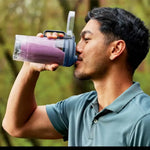 Licuadora Ninja con batido morado, vista frontal, uso al aire libre.