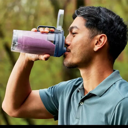 Licuadora Ninja con batido morado, vista frontal, uso al aire libre.