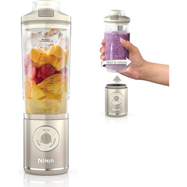 Licuadora personal Ninja dorada con frutas frescas y vaso portátil en mano