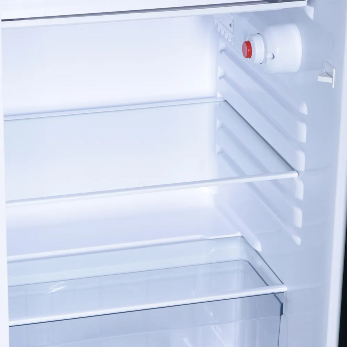nevera mini blanca interior con estantes de vidrio y espacio de almacenamiento