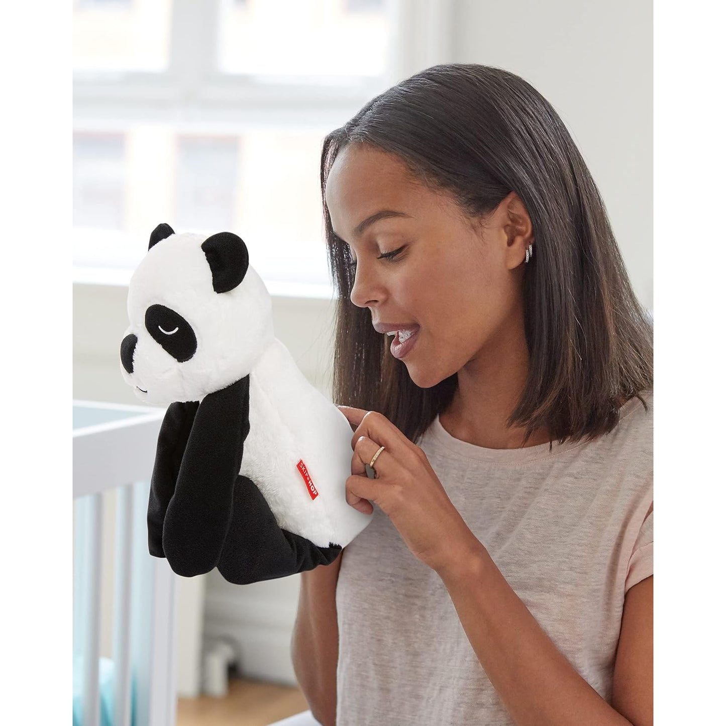 Títere de panda blanco y negro, mujer juega en habitación infantil