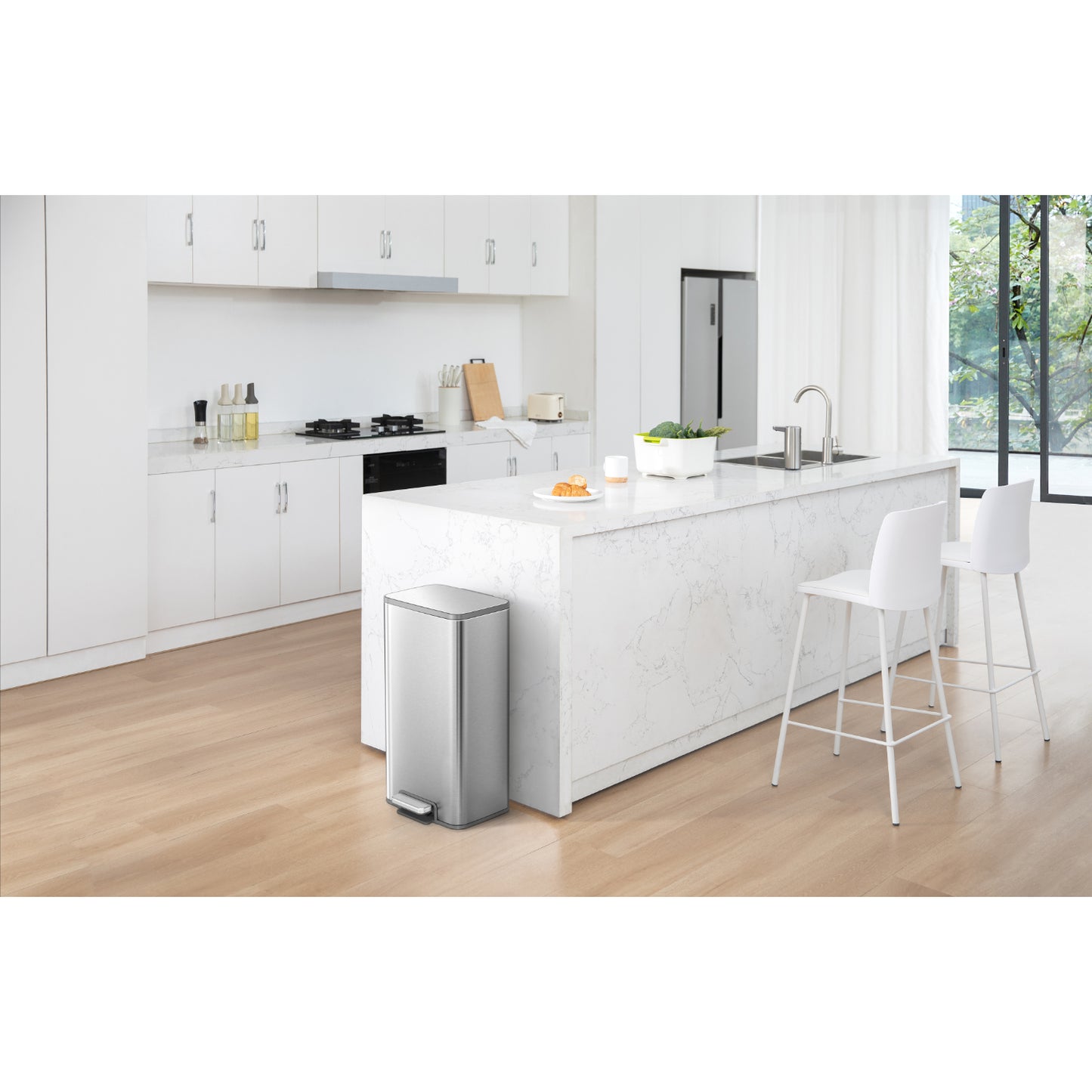 Basurero metálico con pedal 50 litros de EKO en cocina moderna con suelo de madera y barra de mármol