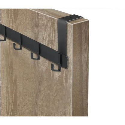 Perchero negro de metal montado en panel de madera clara, ideal para organización en casa