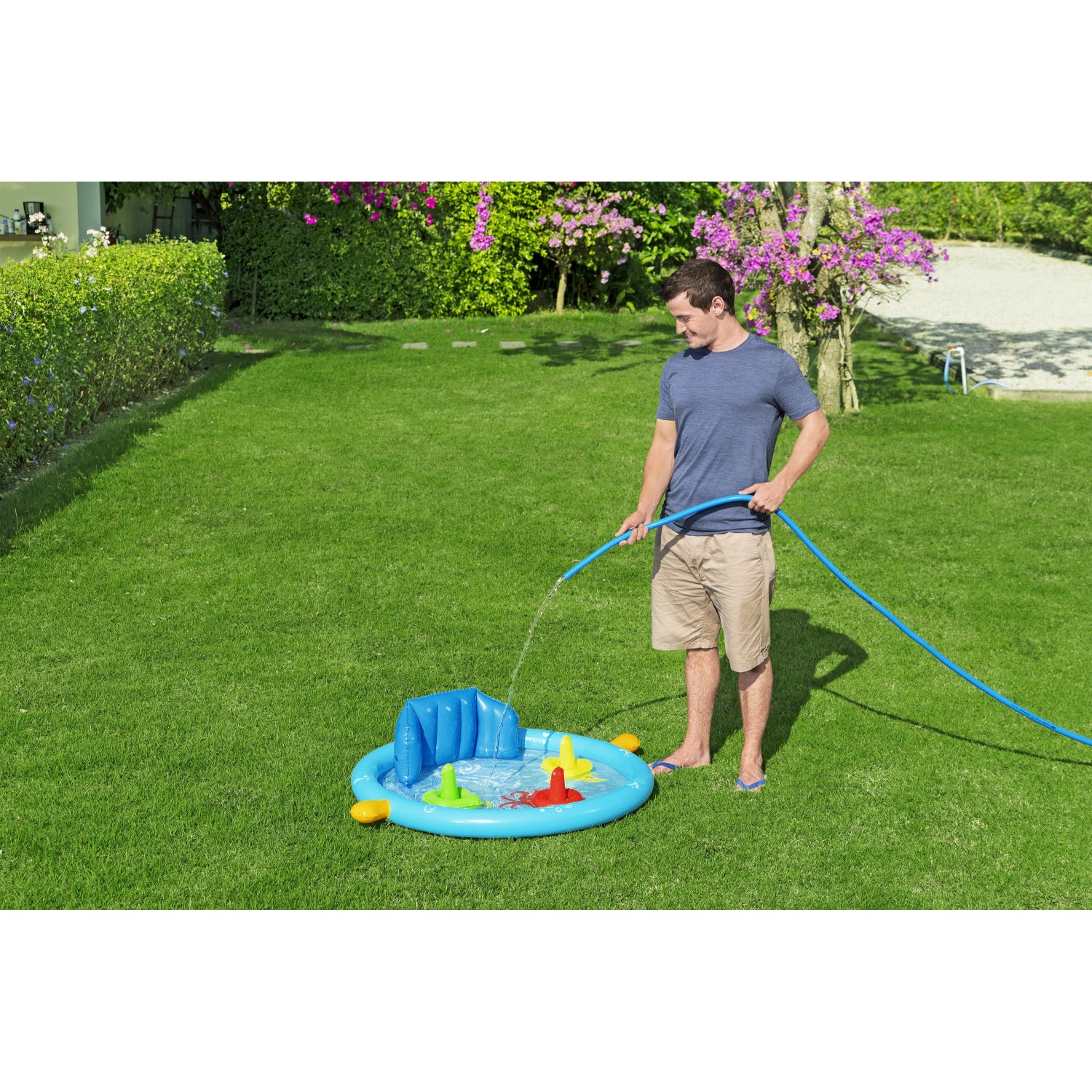 piscina infantil con accesorios azul, vista lateral en jardín