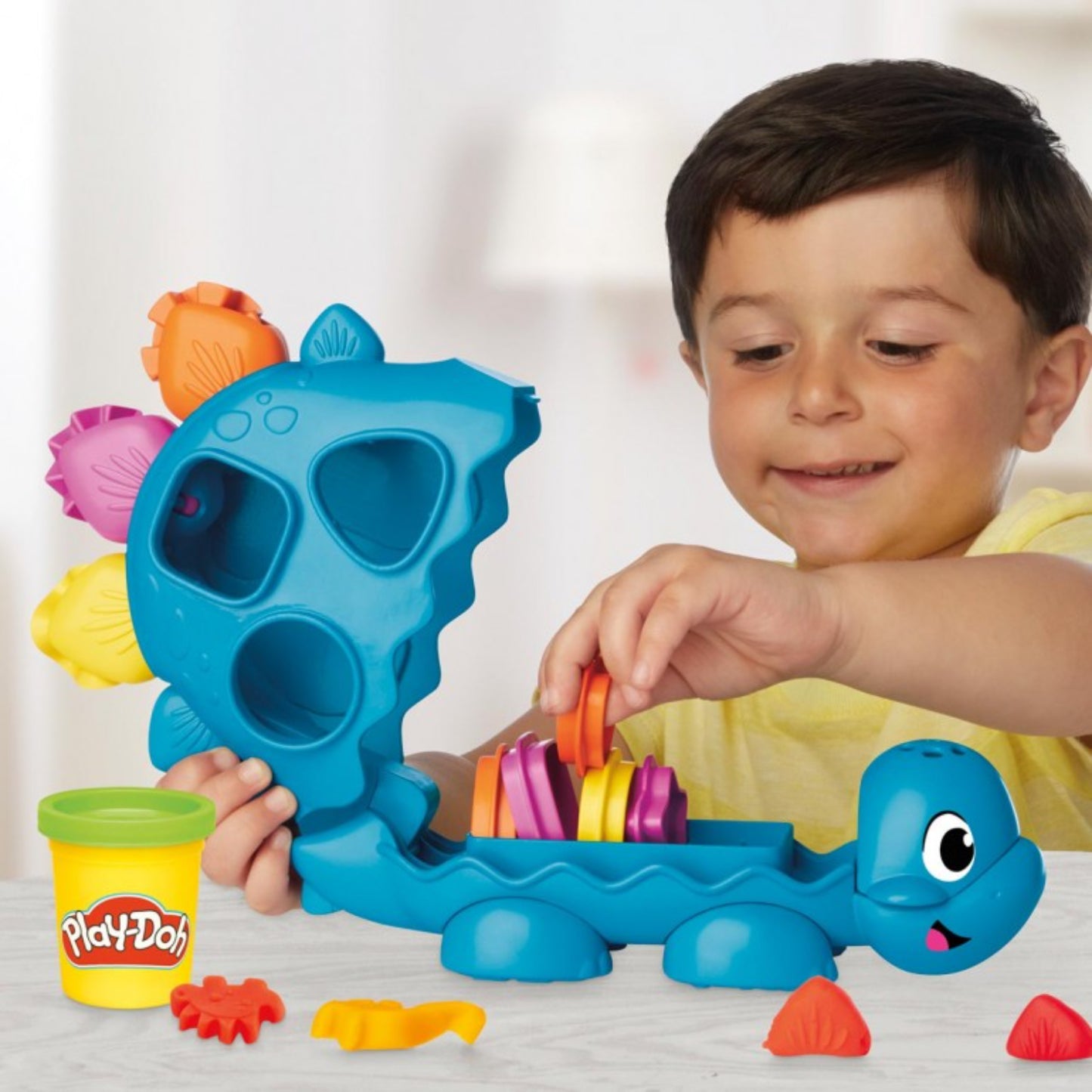Juguete Play-Doh dinosaurio azul, niño jugando con masa, creativo y divertido