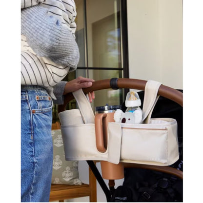 organizador de cochecito beige con compartimentos para botella y biberón