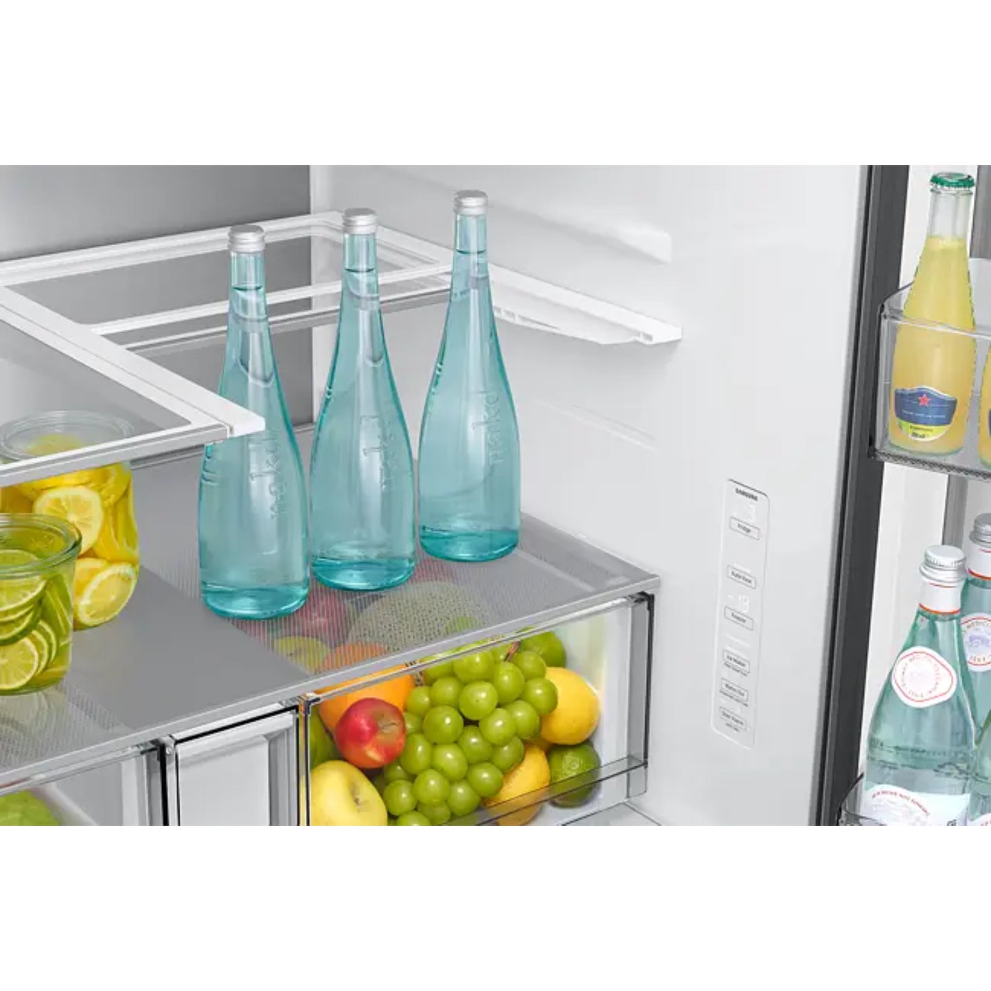 Refrigeradora Samsung blanca interior con botellas y frutas frescas