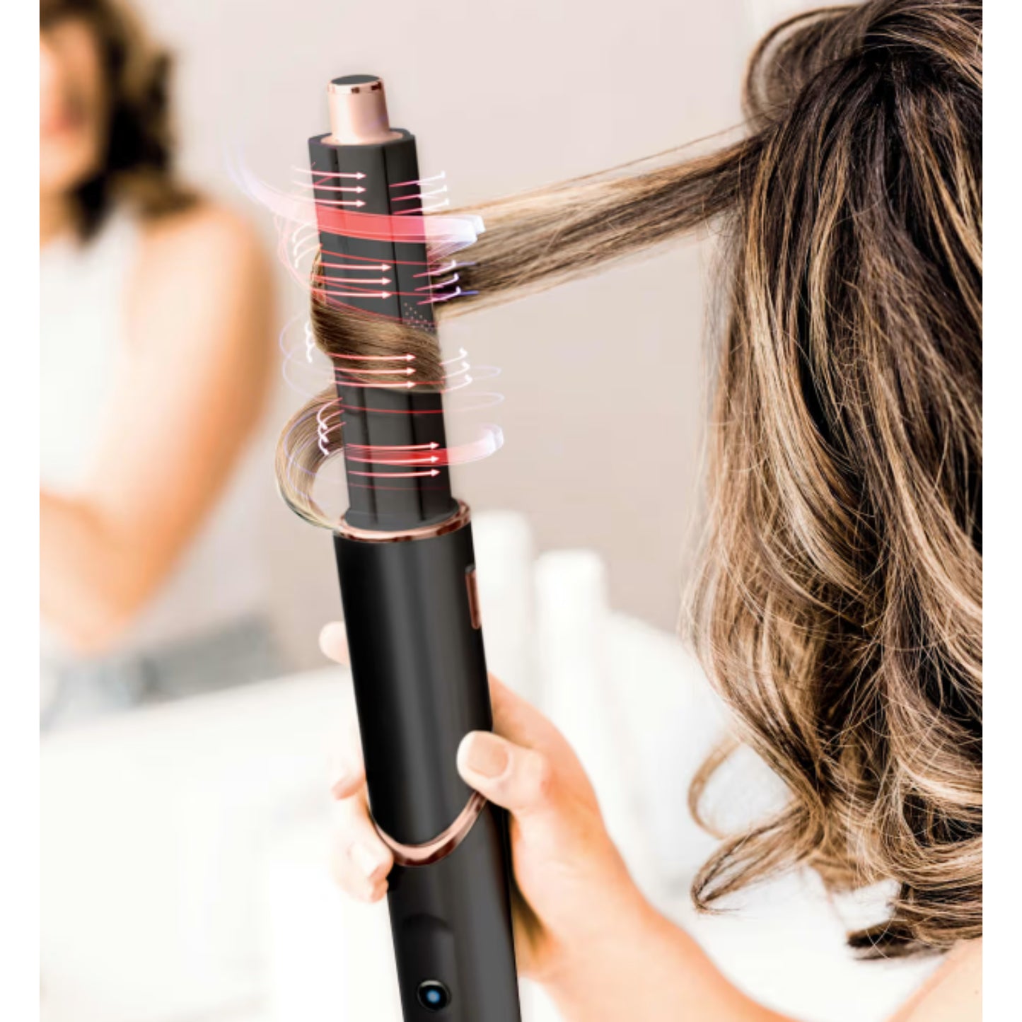 Rizador negro con diseño elegante, vista en uso, creando ondas en el cabello