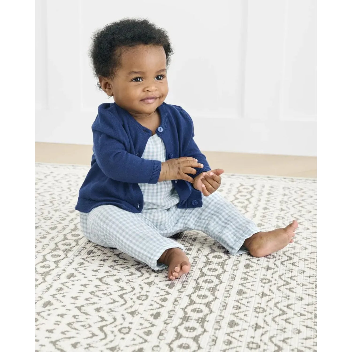 Conjunto de bebé azul marino y azul claro, niño sentado con alfombra de diseño