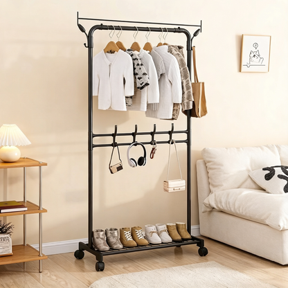 Perchero negro con ropa colgada, zapatos y decoración en sala de estar