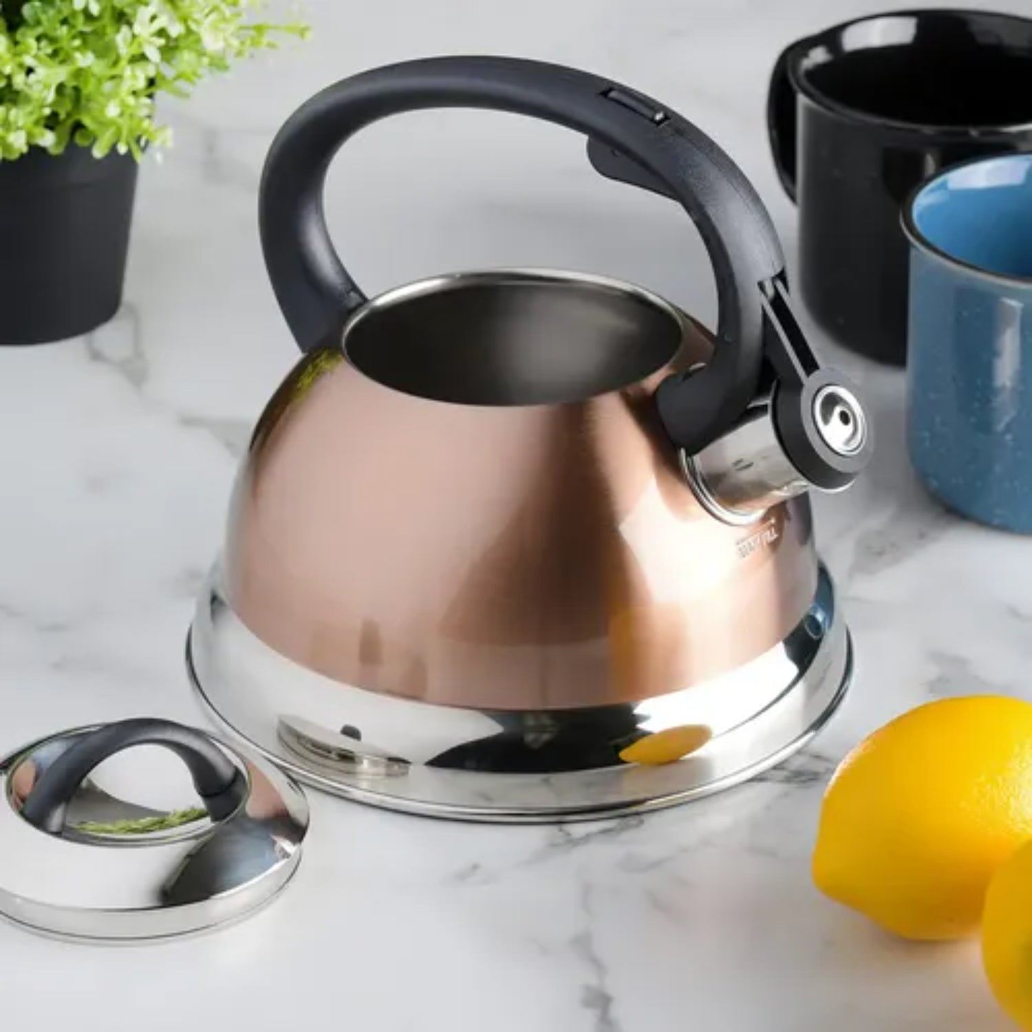 Hervidor de acero inoxidable y cobre, cocina moderna, cerca de limón y tazas