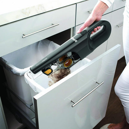 Aspiradora sin cable SHARK negra en uso, limpiando un cajón de cocina