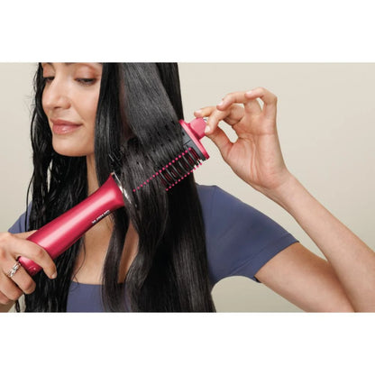 Secador de cabello rosa, vista lateral, alisando el cabello en casa