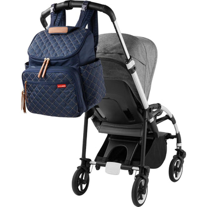 Mochila azul SKIP*HOP en carrito, ideal para transportar accesorios de bebé