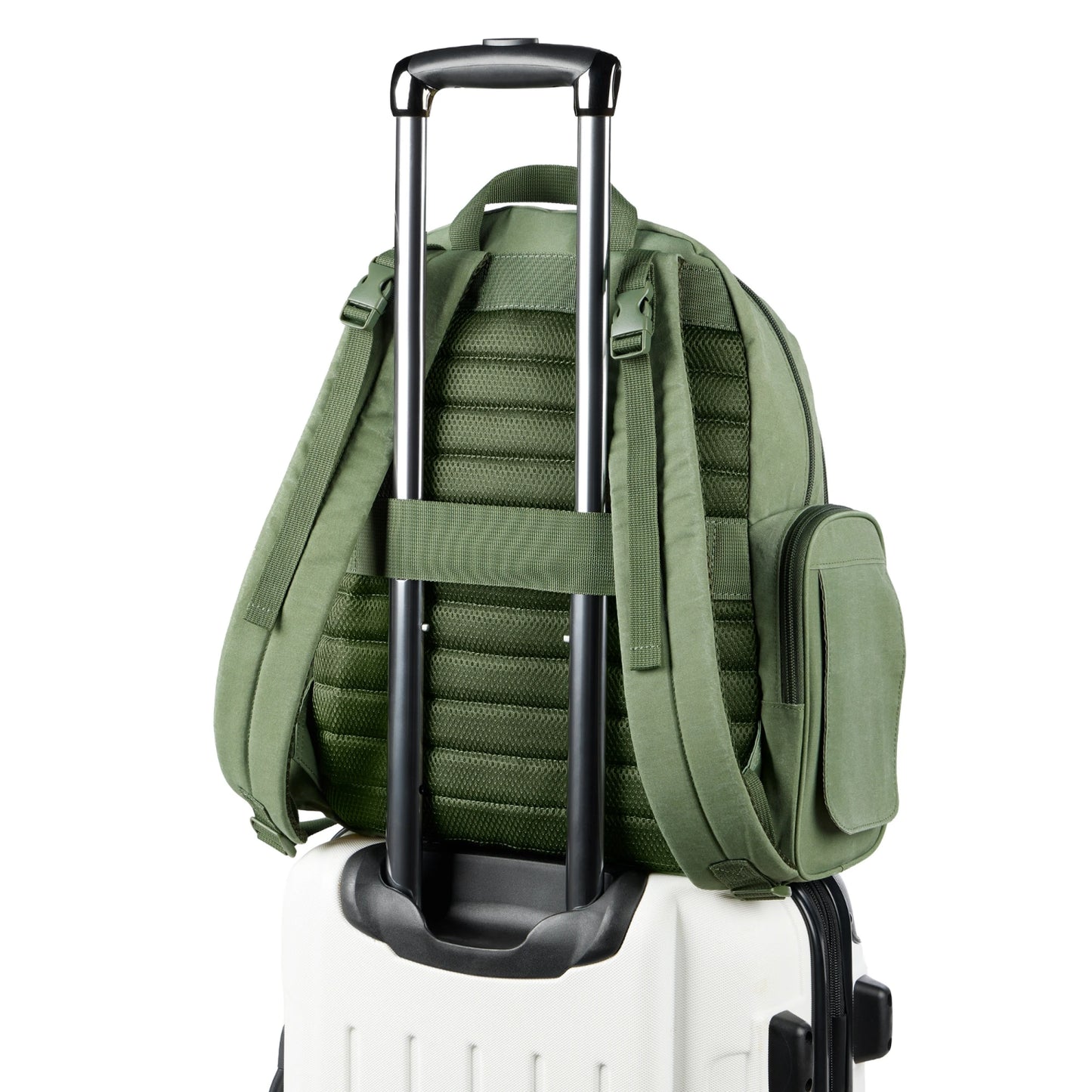 Pañalera verde con asas y correas, vista trasera sobre maleta