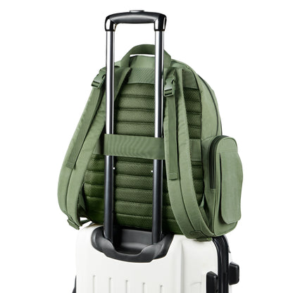 Pañalera verde con asas y correas, vista trasera sobre maleta