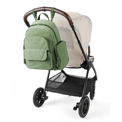 Pañalera verde SKIP*HOP en mochila, vista trasera en carrito de bebé
