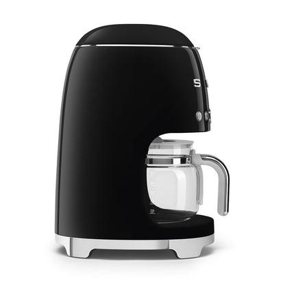 Cafetera negra SMEG con jarra de vidrio, diseño retro en cocina moderna